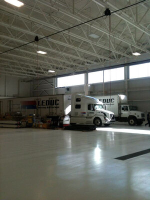 White floors and walls with gleaming white transport units highlight the Leduc Truck Service Warehouse