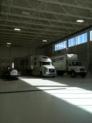 Stark white floors and walls with gleaming white transport units highlight the Leduc Truck Service Warehouse